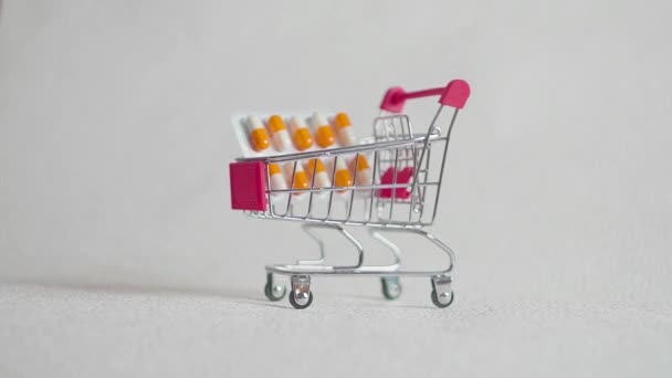 Medicine, pills, drug or tablets in a blister pack in shopping cart on white background for healthcare and medical concept — Stock Video