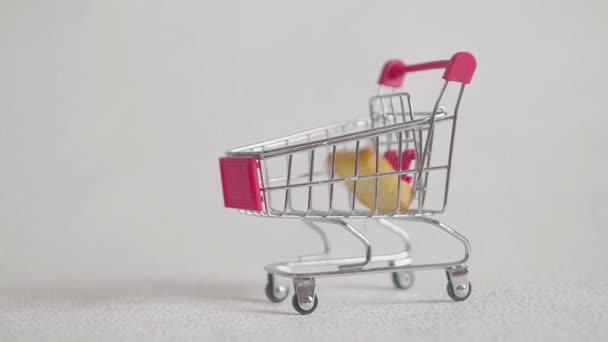 Shopping trolley with pieces of crackers. isolated on white — Stock Video