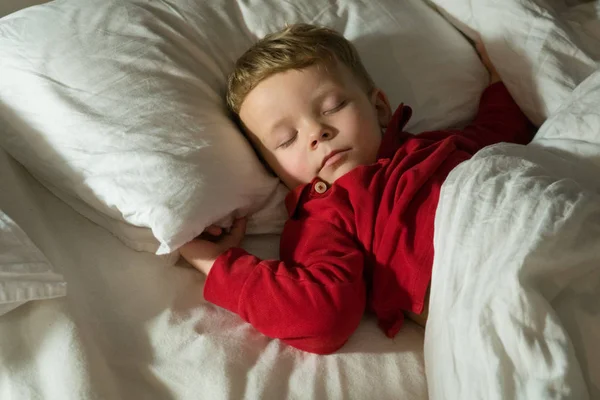 Bebé niño durmiendo en la cama por la noche Imágenes de stock libres de derechos