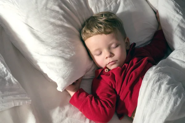 Infant baby boy sleeping in bed at night Stock Picture