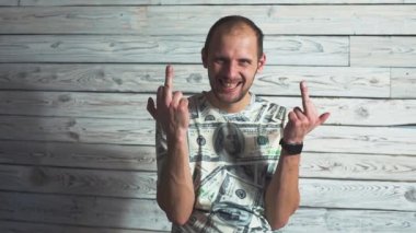 Bir genç sakallı adam gösteren orta parmak el fuck portresi. Beyaz adam dolar bir t-shirt giyen.