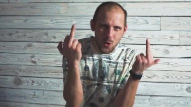 Bir genç sakallı adam gösteren orta parmak el fuck portresi. Beyaz adam dolar bir t-shirt giyen.