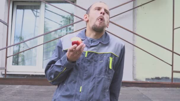 Trabajador de la construcción comiendo una manzana — Vídeo de stock