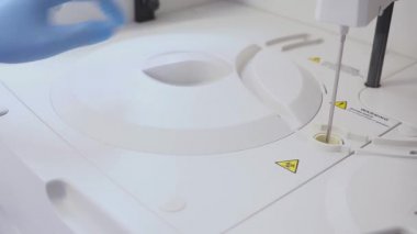 bir kan testi yaptıkları bir laboratuar işçisi. tüpler makineye yükler. Şişeyi Laboratuvar santrifüjler Yükleme Yardımcısı. Kan tüpleri değiştirme.