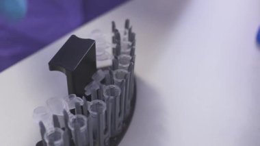 Tarama test tüpü analizi ile hemşire ve bir destek Laboratuvar Şişeler altında koymak. Makine için kan analizi çalışması için hazırlık