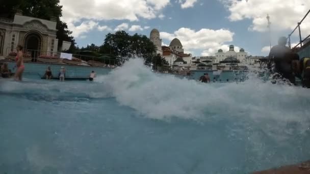 Budapest - 2018. július 2.: kilátás a Gellért fürdő. Mesterséges tengeri hullám, különböző fajú emberek. — Stock videók