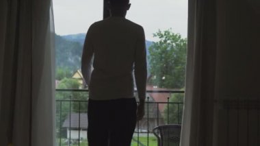 Genç adam onun odasından balkona, bak dağlar gider.