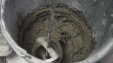 Elektrikli matkapla alçı çözeltisinin karışımı. Ev yenilenmesi