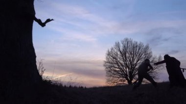 Azrail kavgalar bir adamla bir kurban. gün batımı siluet. ölüm kavramı ve yaşam mücadelesi