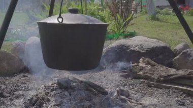 Söz konusu ormanda hazırlamak için sıcak taze yiyecek. Bir kazan ile sıcak taze çorba ya da güveç ya da yulaf lapası tehlikede. Bir ülke evin avlusuna gelsinler. Yakın çekim.
