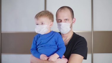 Koruyucu tıbbi maskesi, baba ve oğul klinikte ayakta giyen baba holding şirin küçük toddler bebek çocuk çocuk portresi
