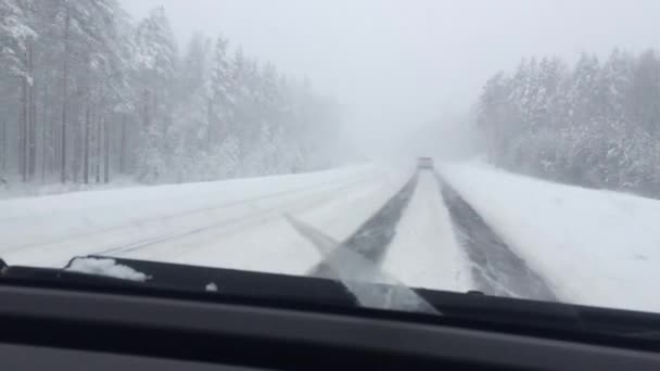 Carretera de invierno en la nieve pesada con fuerte ventisca en el coche en movimiento — Vídeos de Stock