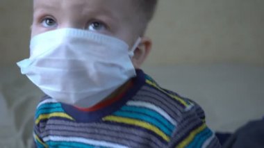 Maskeli bir çocuğun yakın çekimi. Hastalıklı hasta çocuk.