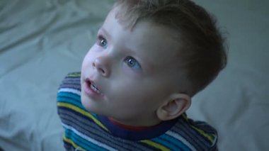 Bir iki yıl yaşlı erkek çocuk ev bir projektör film izliyor, kapat.