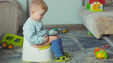 Çok güzel çocuk Oda lazımlık eğitimi sırasında bir akıllı telefon ile.