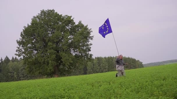 Чоловік працює з позначкою Європейського Союзу в заміському пейзажі. Стандартний пред'явника — стокове відео