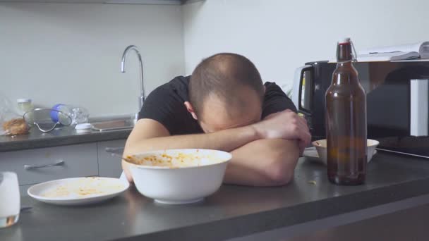 Man with a hangover at the table in the kitchen. after party — Stock Video