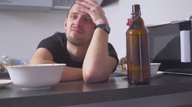 Akşamdan mutfak masasında olan adam. partiden sonra