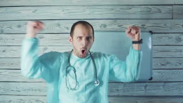 快乐的白人男性医生，留着淡淡的胡子，在他的医务室里跳舞 — 图库视频影像