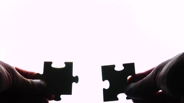 Puzzel in handen geïsoleerd op witte achtergrond — Stockvideo