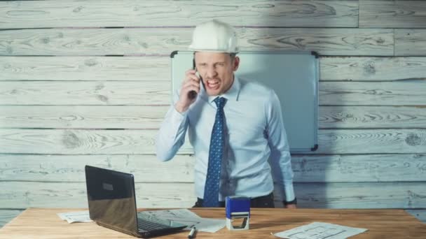 Rozzlobený nervózní architekt pracuje na výkresy nových projektů a mluví o telefonu. — Stock video