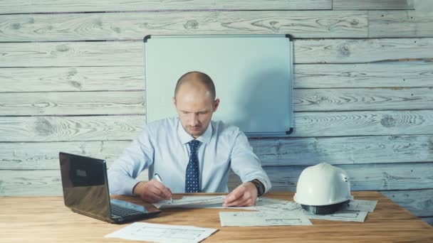 Ingénieur ou contremaître travaillant avec la documentation du projet dans le bureau . — Video