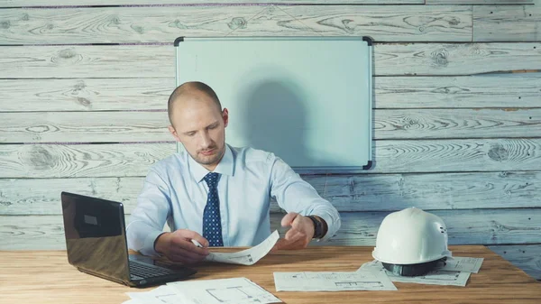 Ingeniero supervisor trabajando en dibujos en la oficina. — Foto de Stock