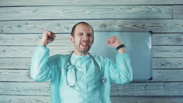 Happy male Caucasian doctor with light beard dancing in his medical office — Stock Photo, Image