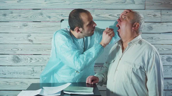 Doktor otolaryngologist üst düzey bir erkek hasta 4 k Boğazı kontrol