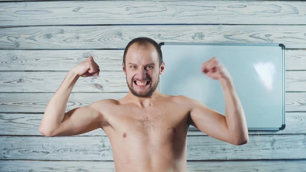 Komik zayıf sporcu antreman. İnce bir adam kas gösterir