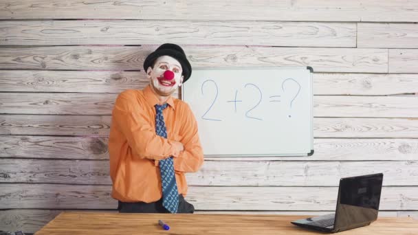 Ritratto di simpatico clown vicino alla scuola o alla lavagna studentesca. Stupido insegnante che spiega agli studenti il compito — Video Stock