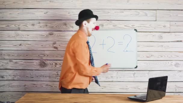 Portret van schattige mannelijke clown in de buurt van de school of student Blackboard. Stomme leraar uit te leggen aan studenten de taak — Stockvideo