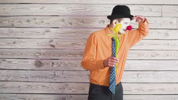 Clown con fiori di tulipano in concetto divertente. Uomo innamorato ad un appuntamento Aspettando il tuo amore — Video Stock