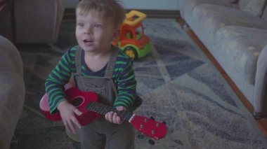 neşeli küçük çocuk gitar şarkı ve dans oynuyor