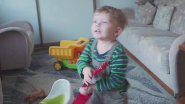 Веселый мальчик играет на гитаре, поет и танцует. — стоковое видео