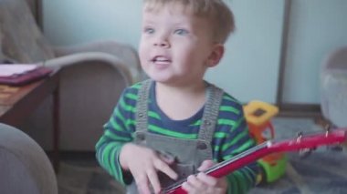 neşeli küçük çocuk gitar şarkı ve dans oynuyor