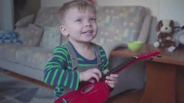 neşeli küçük çocuk gitar şarkı ve dans oynuyor
