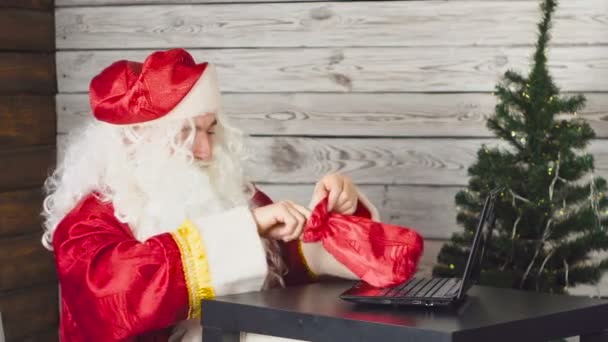 Papá Noel trabajando en una computadora en la oficina. Tenencia de dinero . — Vídeo de stock
