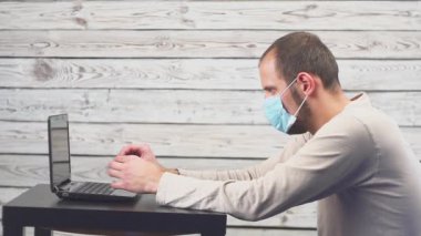 Hasta işadamı sıcaklık ve çalışma office baş ağrısı ile dizüstü bilgisayar kullanın. Öksürük ile yüz maskesi giyen adam.