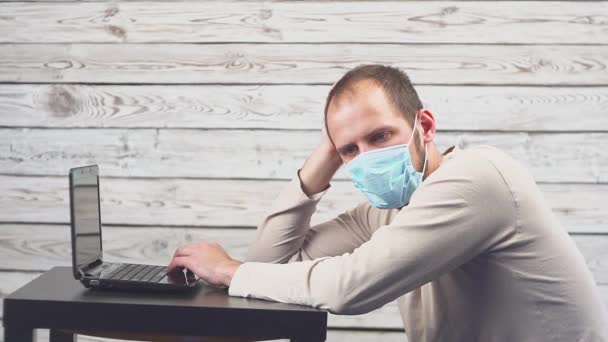Kranke Geschäftsleute nutzen im Büro Laptop-Computer mit Temperaturschwankungen und Kopfschmerzen. Mann trägt Gesichtsmaske mit Husten. — Stockvideo