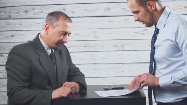 Glimlachend jonge manager overtuigt een client om een contract te ondertekenen. — Stockvideo