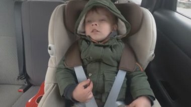 Arabanın arka koltuğunda küçük bir çocuk uykuya dalın. Araba kötü bir yola gidiyor. Bebek ile seyahat