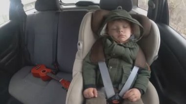 Zaman laboratuvarı. arabanın arka koltuğunda küçük bir çocuk. Araba kötü bir yola gidiyor. Bebekle seyahat. Bir gitar ile uyuyan çocuk.