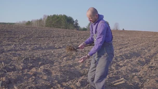 Farmer examina la calidad del suelo en la granja agrícola fértil. granjero está sosteniendo la tierra en sus manos. Concepto de agricultura ecológica — Vídeos de Stock