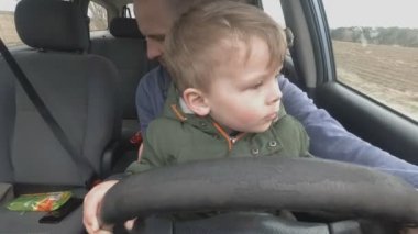 baba araba sürmek için iki yaşındaki oğlu öğretir.