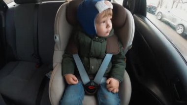 Arabada çocuk koltuğunda oturan küçük çocuk. Zaman atlamalı. Büyük şehir ritmi