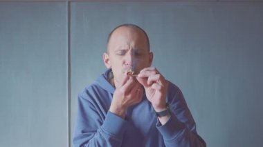 portre genç adam kapalı kapalı bir sigara içen closeup. duman yangın ışığı.