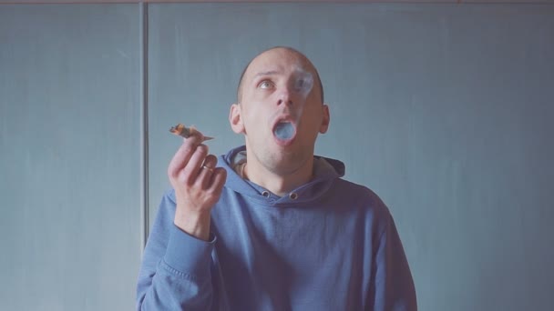 Portre genç adam kapalı kapalı bir sigara içen closeup. duman yangın ışığı. — Stok video