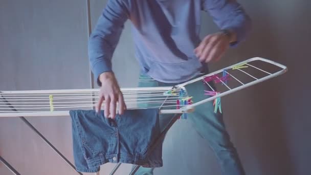 Man hangs clothes on the dryer. Kids clothes. Lonely father — Stock Video