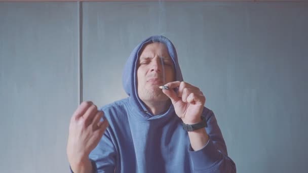 Retrato jovem fumando um cigarro interior closeup. fumaça fogo luz . — Vídeo de Stock